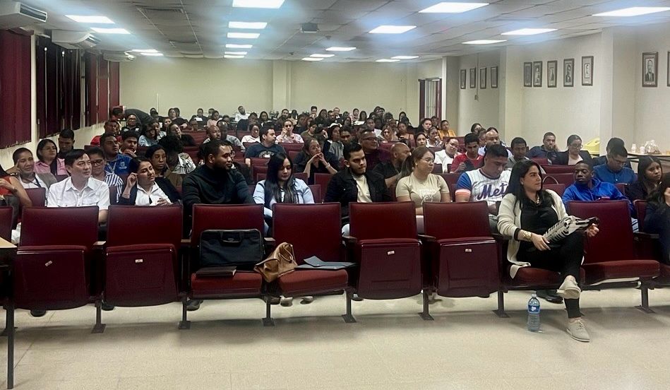 Estudiantes de derecho y profesionales sentados en el auditorio de la Universidad de Panamá durante la conferencia sobre inteligencia artificial.
